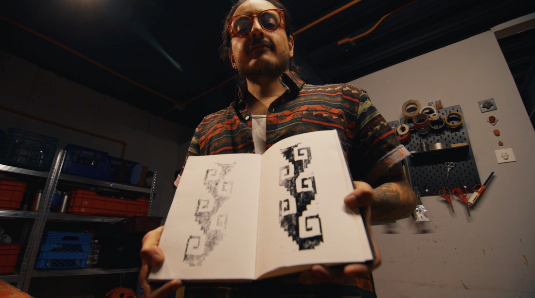 Hugo Mael mostrando los primeros bocetos del patrón inspirado en las grecas de Mitla para la camisa de lino CHIDO.