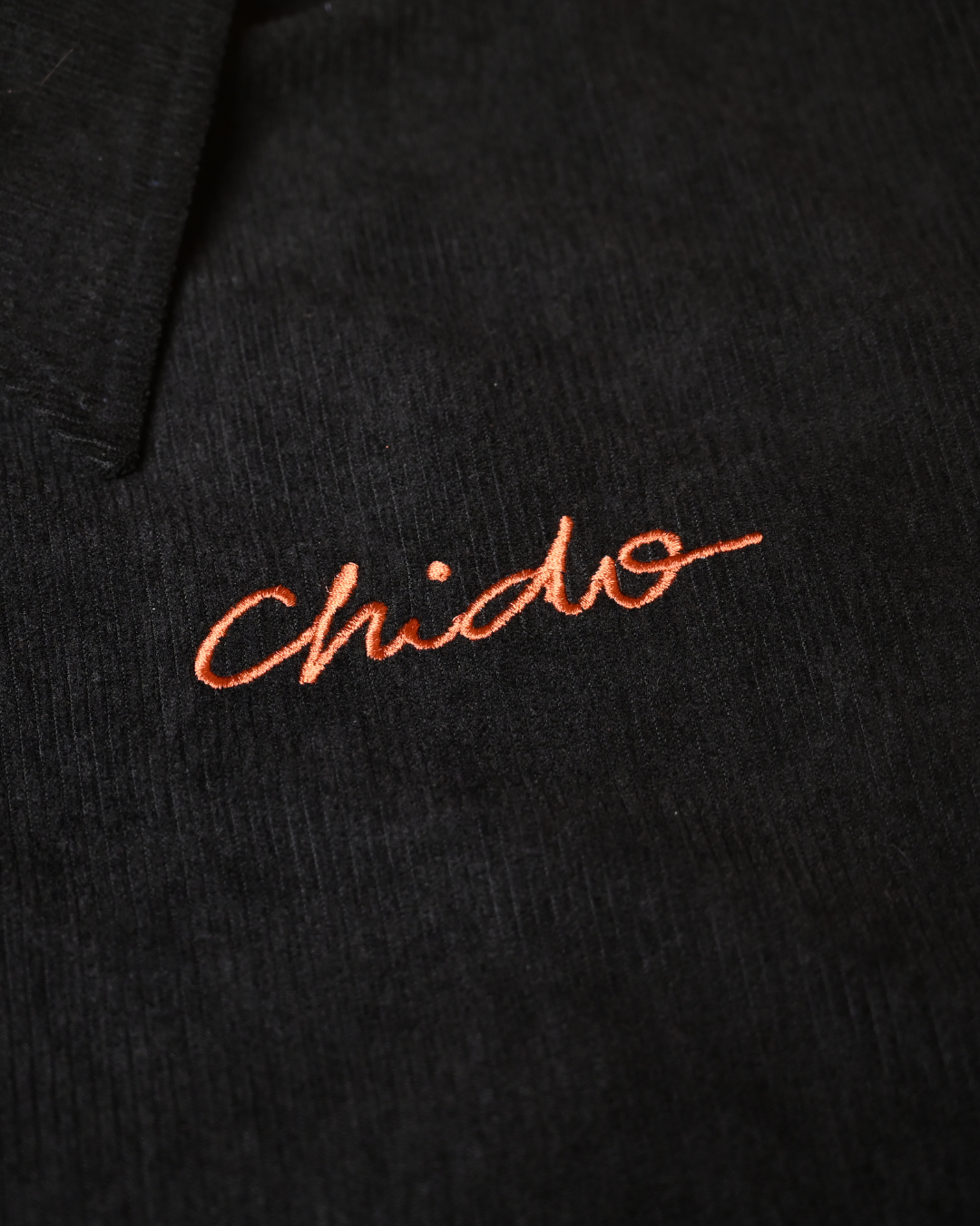 Embroidered CHIDO logo detail on black corduroy jacket