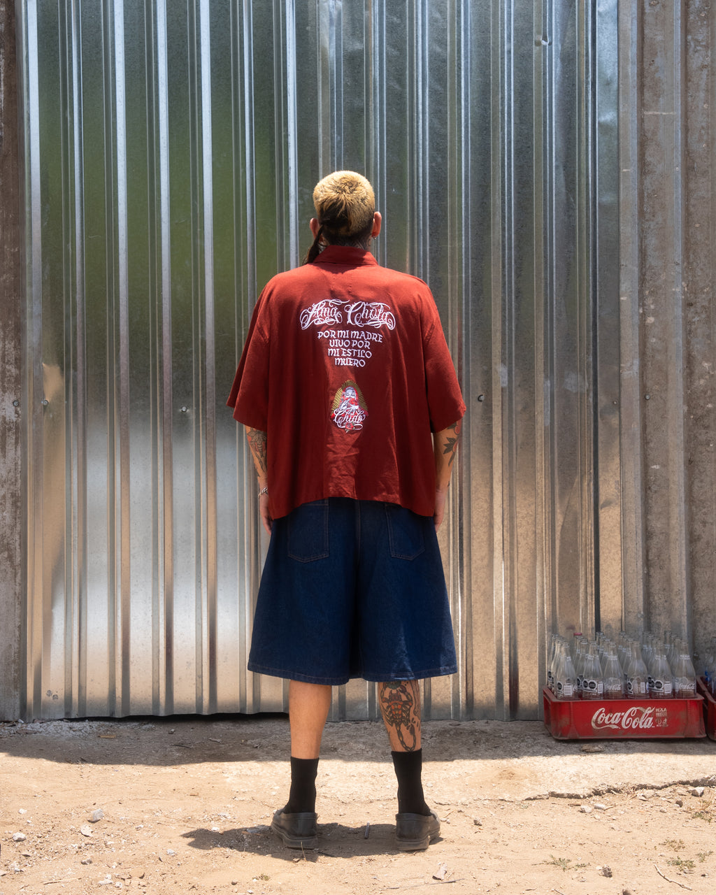 Vista trasera de la Camisa Boxy Roja Tinto Amá Chola CHIDO destacando el bordado inspirado en la cultura chola mexicana.