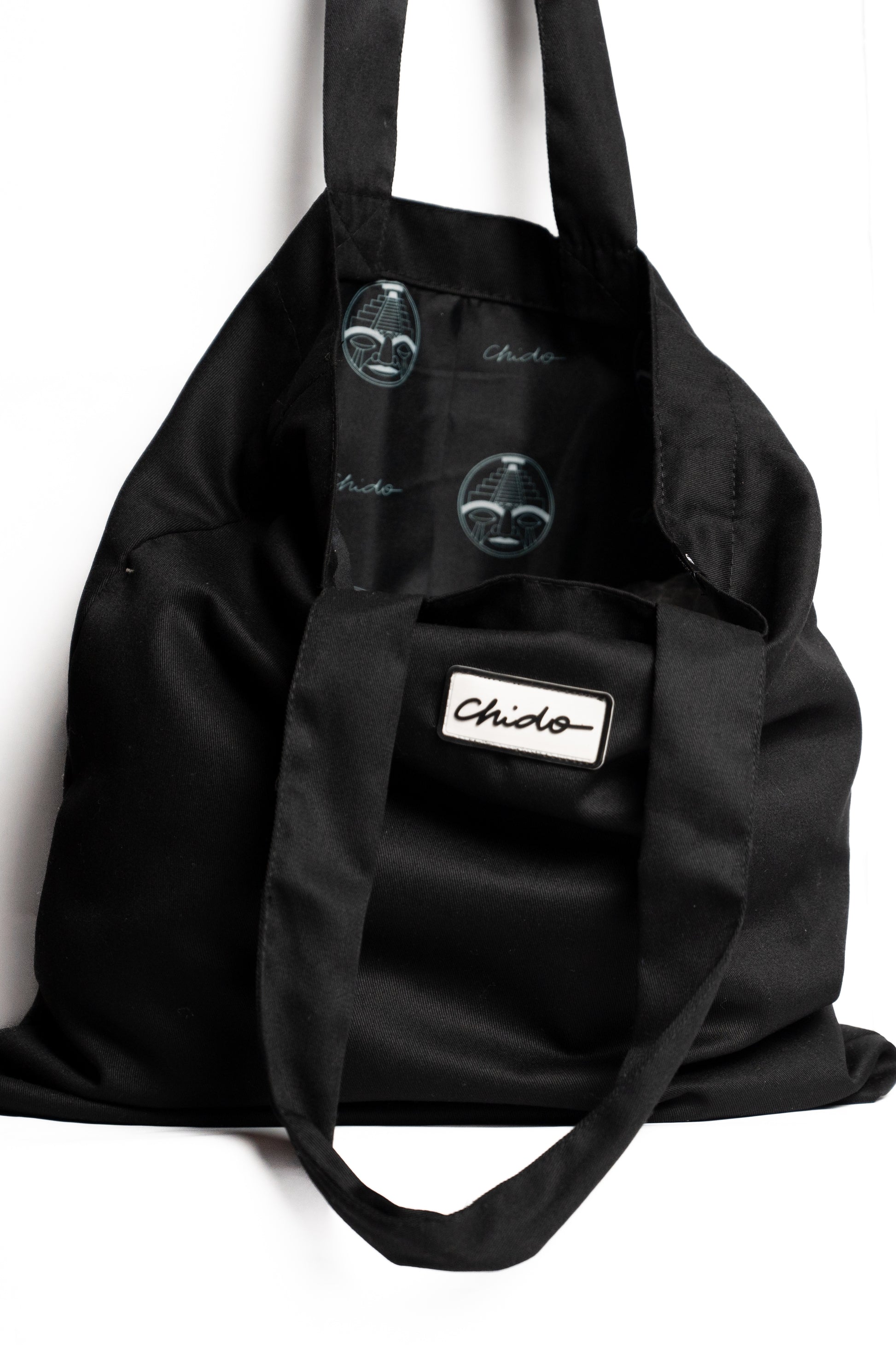 Vista lateral de la tote bag negra CHIDO de tela resistente