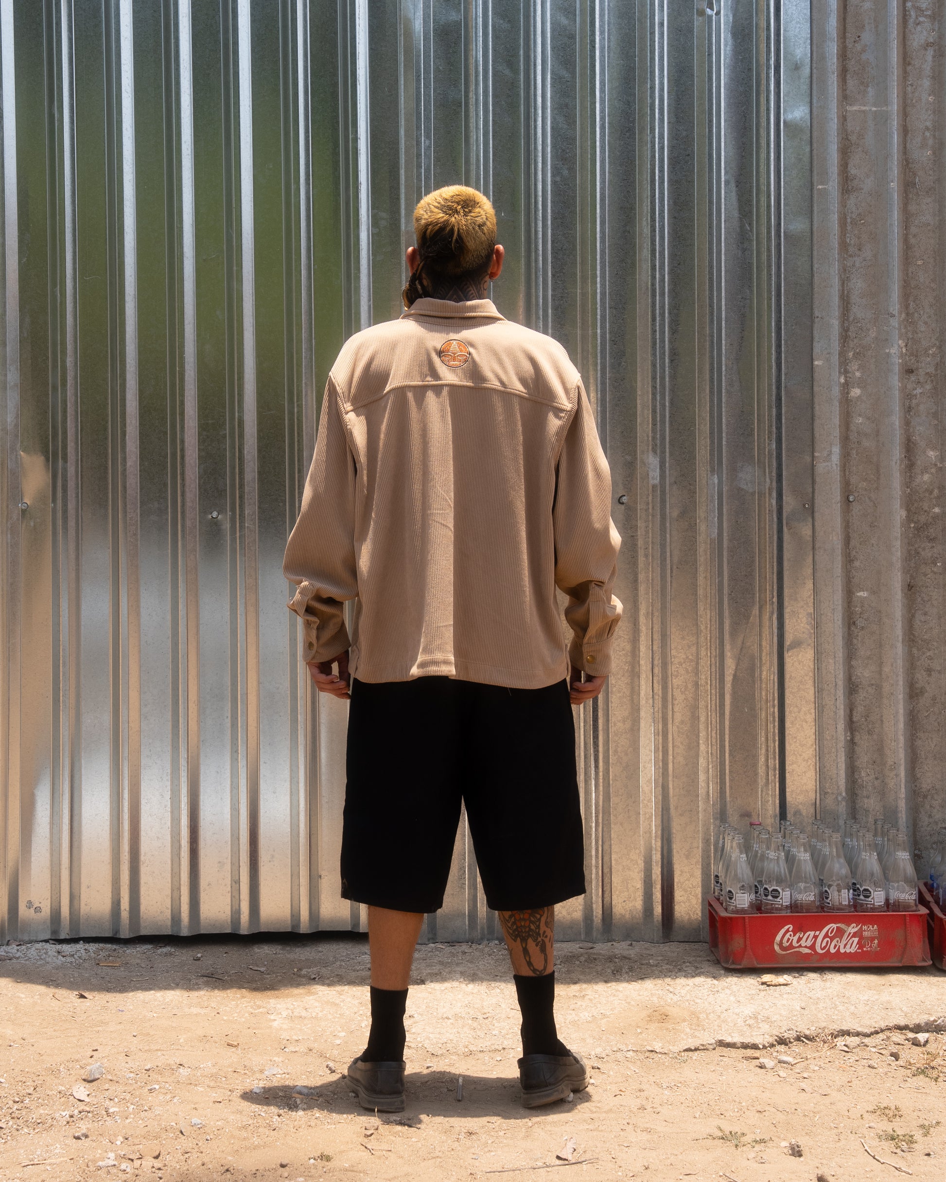 Back view of beige corduroy jacket with embroidered patch