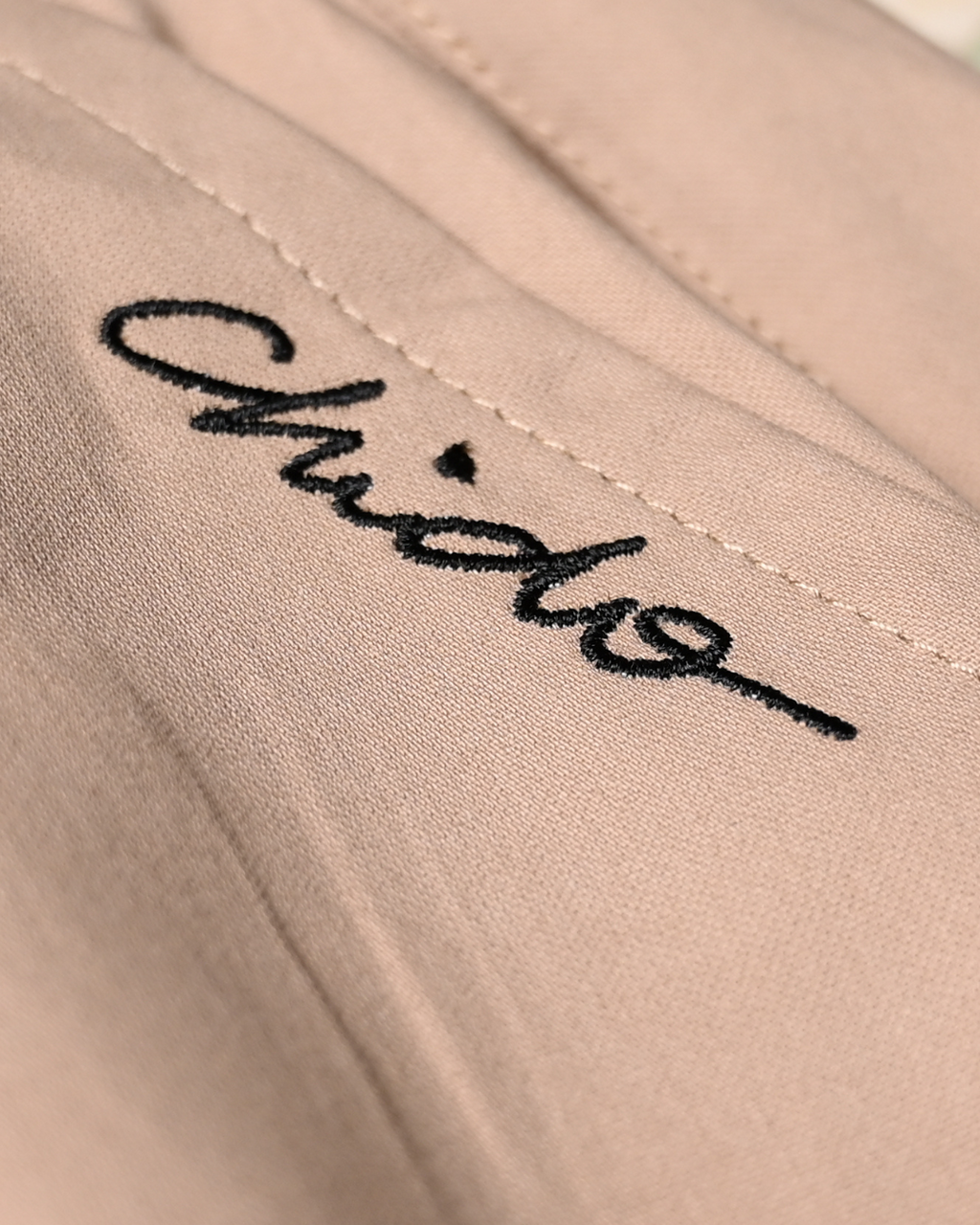 Detalle del bordado Signature en bermuda beige