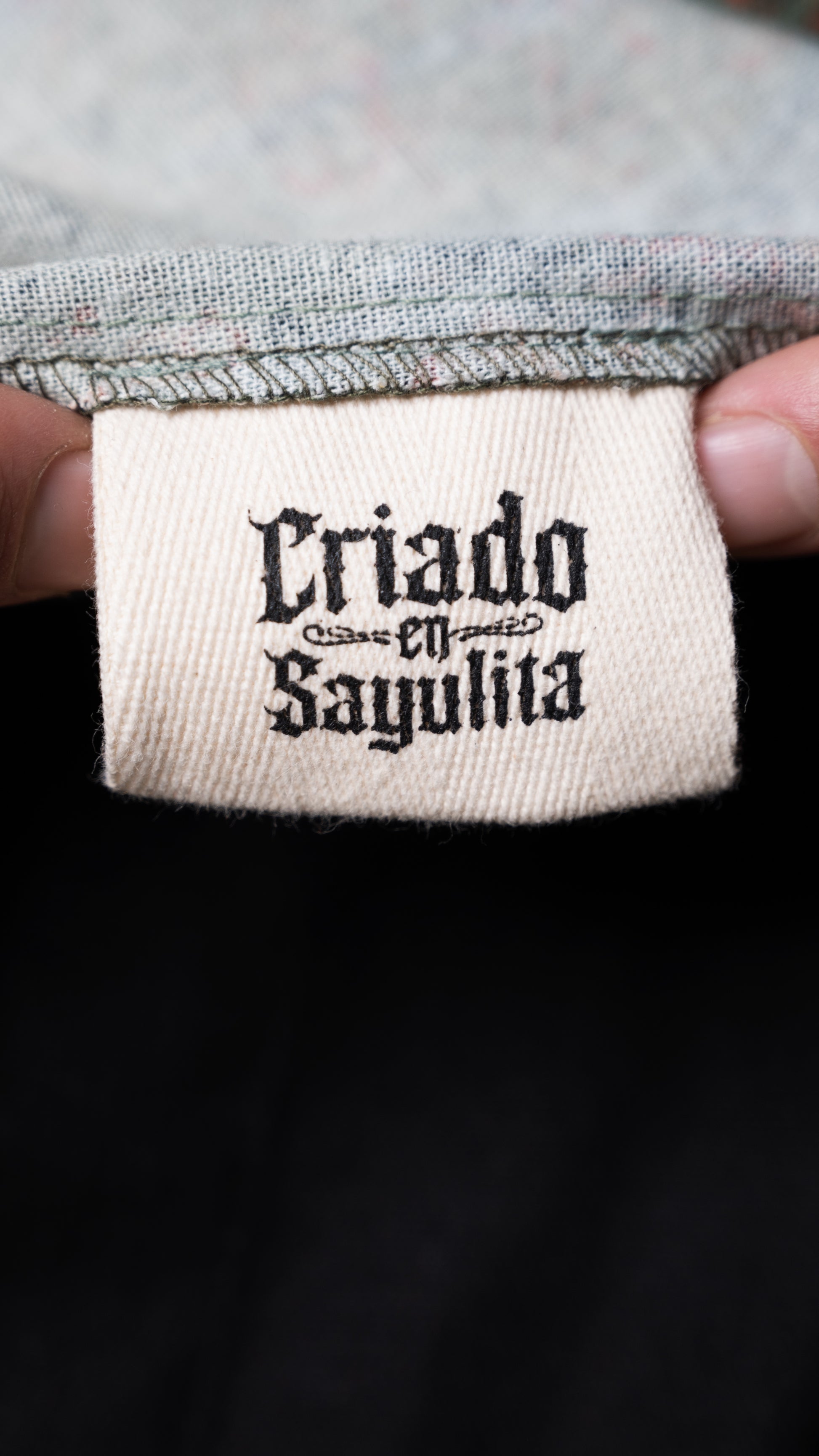 Detalle de etiqueta CHIDO en camisa de lino negra Signature.