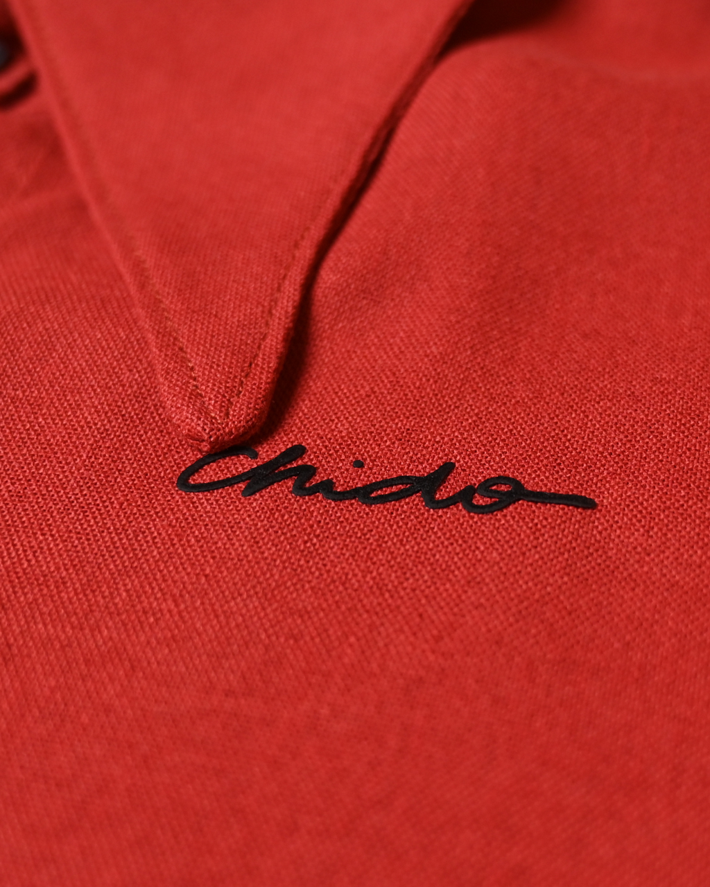 Detalle del bordado CHIDO en camisa de lino roja