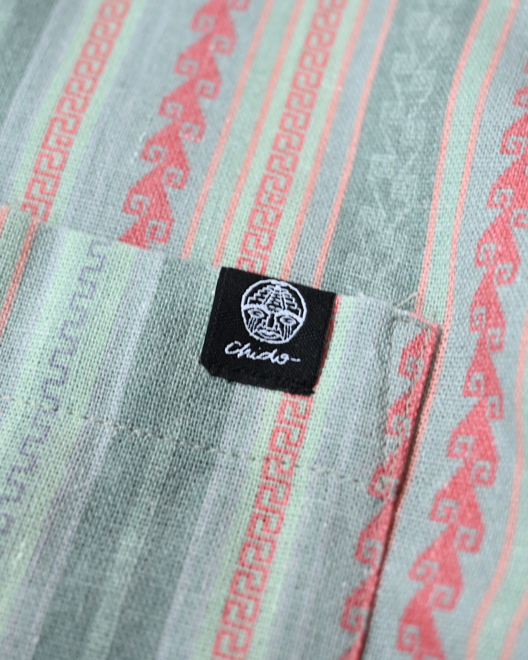 Detalle del tejido, bolsillo y etiqueta de la Camisa Boxy Mitla verde – CHIDO