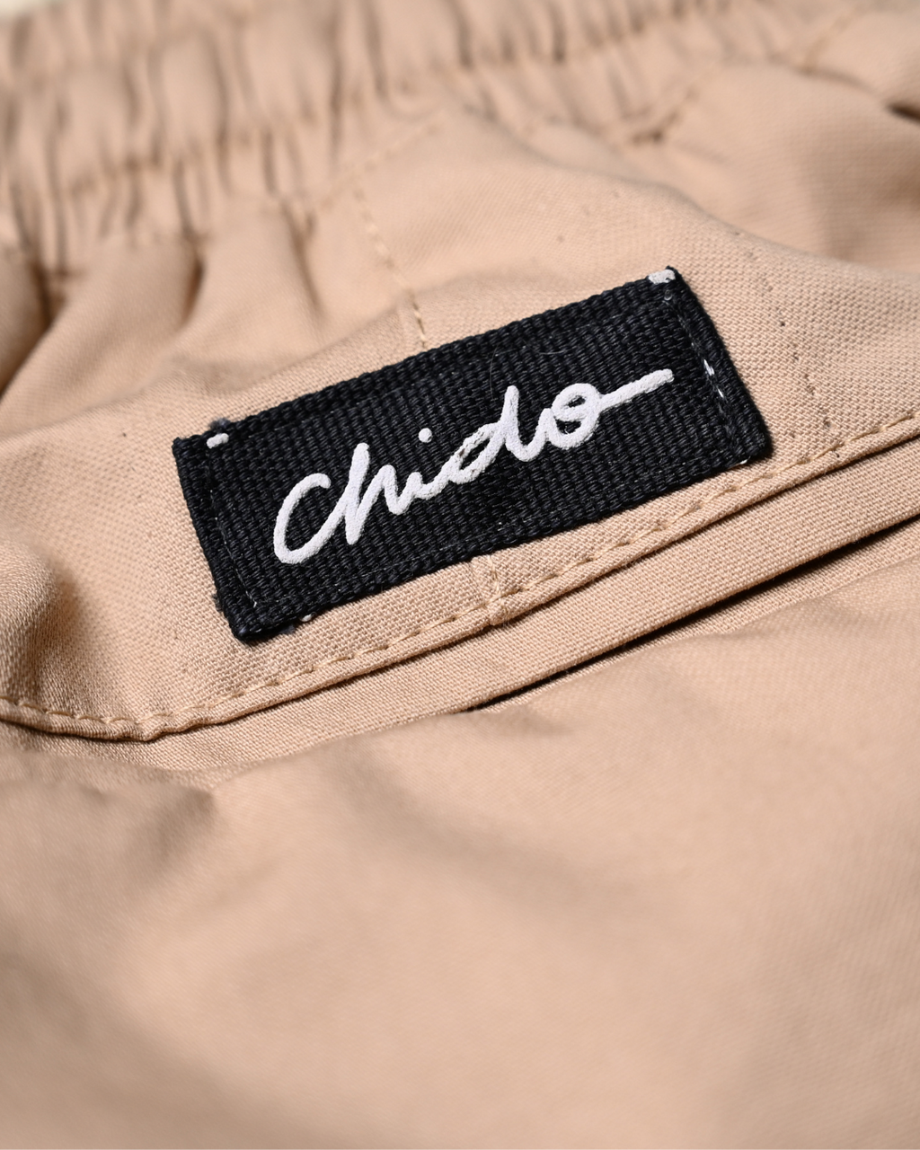 Etiqueta CHIDO en bermuda oversize beige Signature